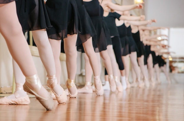 Pequeñas bailarinas que hacen ejercicios clase de ballet.