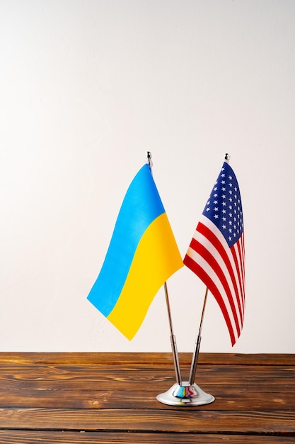 Pequeñas banderas de EE.UU. y Ucrania en los postes de bandera de cerca