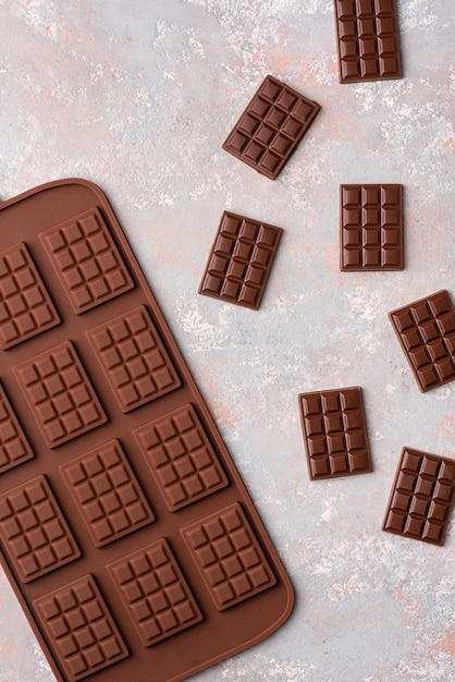 Foto pequenas barras de chocolate sobre um fundo claro