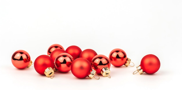 Foto pequeñas bolas de navidad rojas sobre un fondo blanco aislado.