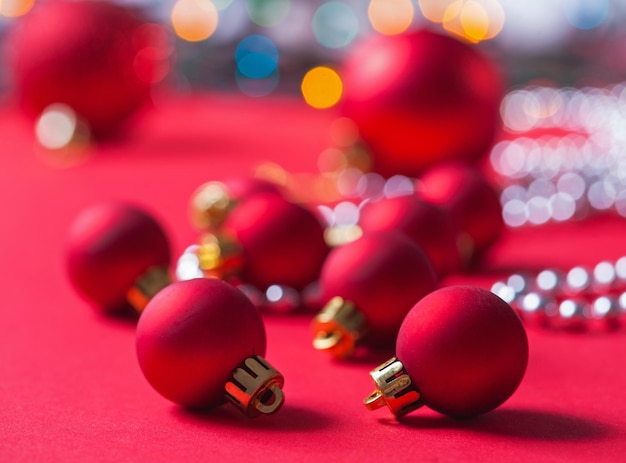 Pequeñas bolas de Navidad rojas sobre fondo rojo.