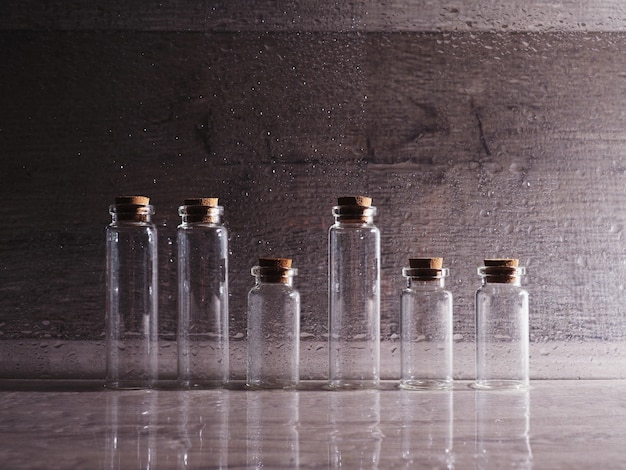 Foto pequeñas botellas de vidrio con tapa de corcho. burbujas vacías en luz contorneada