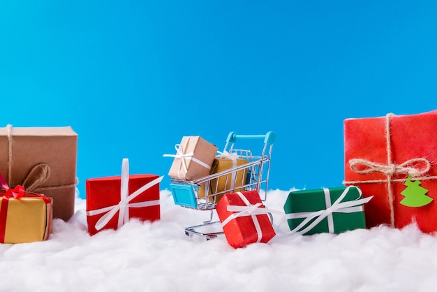 Pequeñas cajas de regalo en carro de supermercado