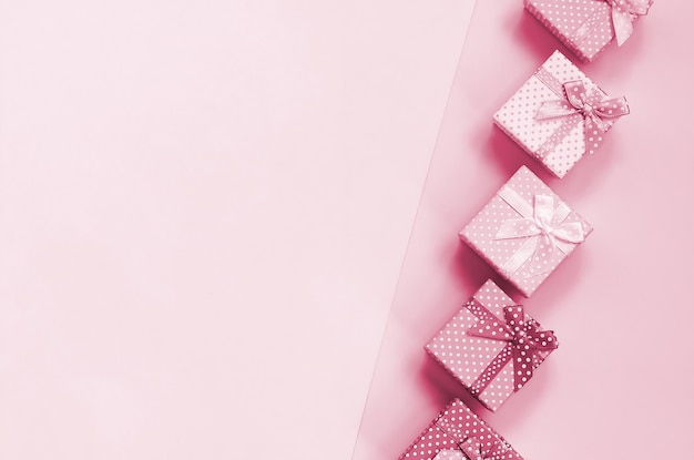 Pequeñas cajas de regalo de diferentes s con imagen de cintas tonificadas en color viva magenta del año.