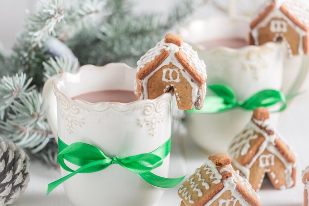 Pequeñas casitas de pan de jengibre con bebida dulce para Navidad