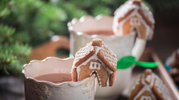 Pequeñas casitas de pan de jengibre con chocolate caliente para Navidad