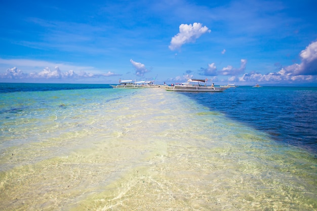 Pequeñas embarcaciones en la playa tropical blanca