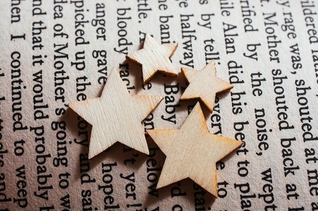 Pequeñas estrellas de madera colocadas en la página del libro