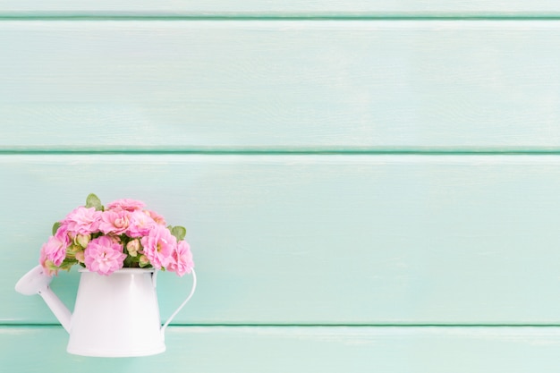 Pequenas flores cor de rosa em vaso decorativo.