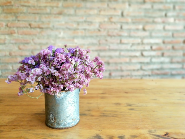 Las pequeñas flores violetas en decoran pueden en la tabla de madera