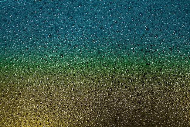 Pequenas gotas de água ou condensado na superfície metálica são amarelas e azuis Fundo abstrato para um protetor de tela
