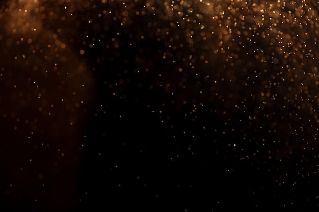 pequeñas gotas de lluvia nieve en un fondo negro viento fondo natural dorado