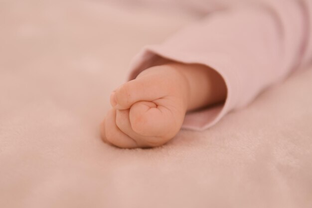 Pequeñas manos de una niña recién nacida sobre un fondo claro