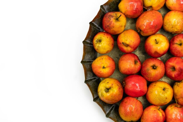 Pequeñas manzanas rojas maduras Ranetka en una placa de metal sobre un fondo blanco Fondo aislado