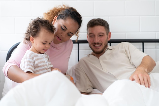 Pequenas meninas pai ler histórias para as crianças antes de ir para a cama para relaxar e dormir profundamente