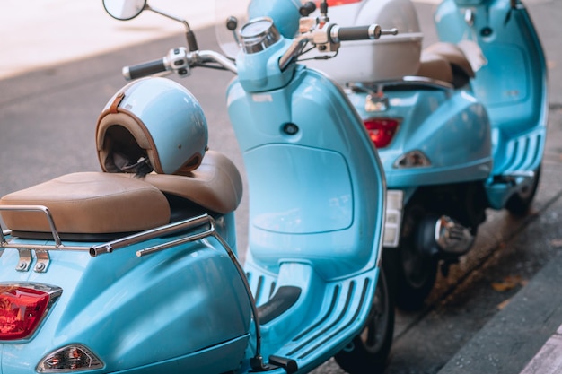 Foto pequeñas motos bastante azules con cascos están estacionadas cerca de la carretera