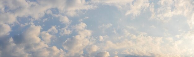 Pequeñas nubes blancas y rosadas en el cielo de la mañana a la luz del sol brillante