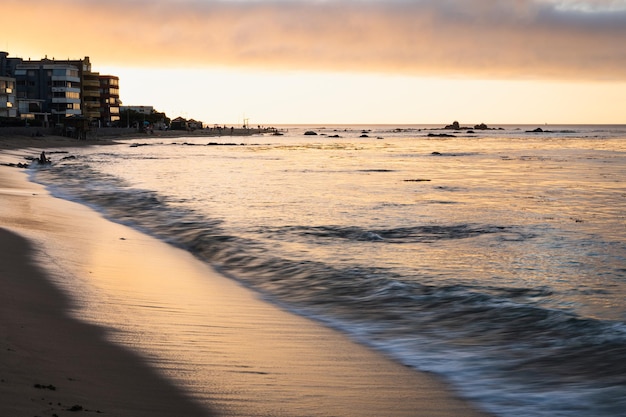 Foto pequenas ondas alcançando a costa ao pôr do sol na praia de algarrobo chile férias de verão no destino turístico