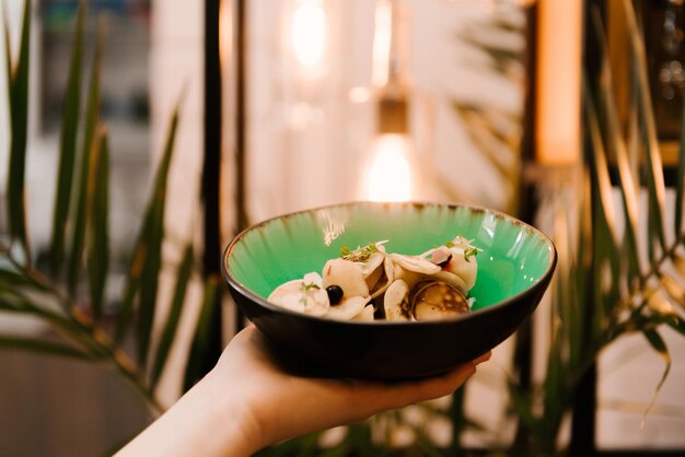 Pequenas panquecas em um prato com bagas e sobremesas caseiras de creme de leite em um foco seletivo de menu infantil de café