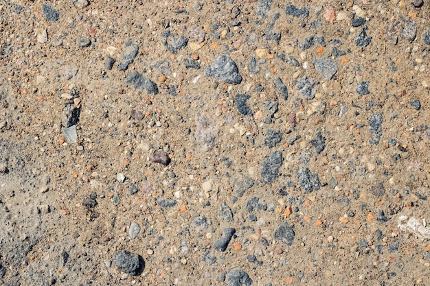 Pequenas pedras na areia amarela fecham