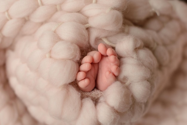 Pequeñas piernas hermosas de un bebé recién nacido en los primeros días de vida Pies de bebé de un recién nacido