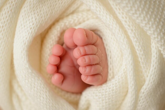 Pequeñas piernas hermosas de un bebé recién nacido en los primeros días de vida Pies de bebé de un recién nacido