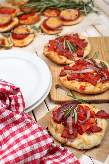 Pequeñas pizzas en papel para hornear de cerca