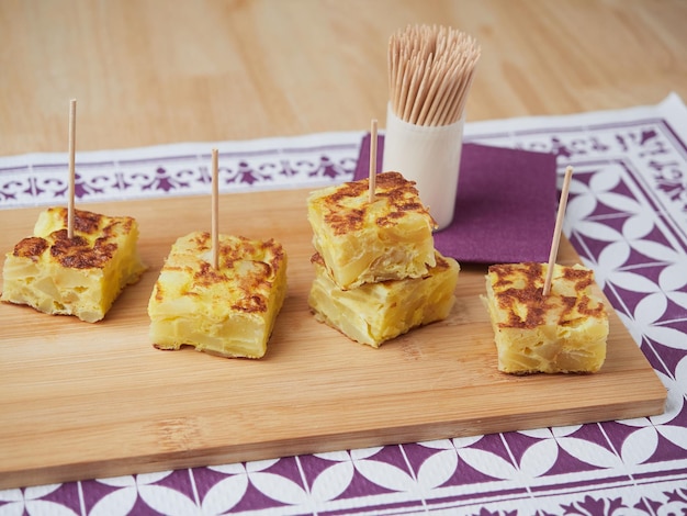 Pequenas porções de omelete de batata servidas como tapas espanholas típicas com pauzinhos chamados pinchos