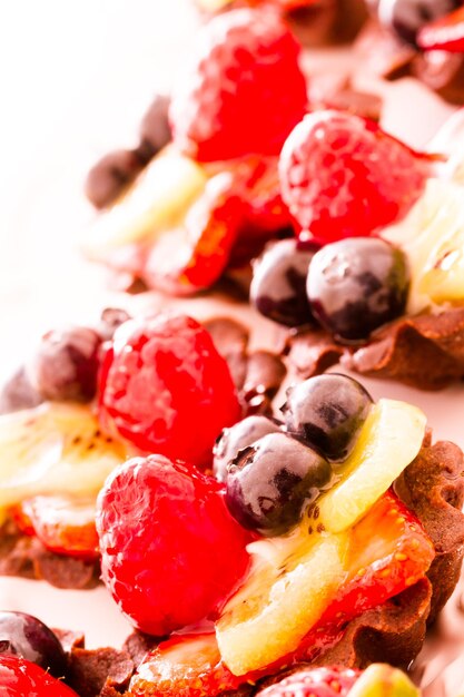 Pequeñas tartaletas de fruta fresca en la barra de postres.