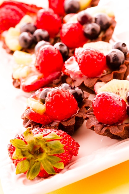 Pequeñas tartaletas de fruta fresca en la barra de postres.