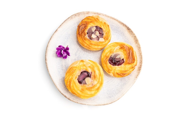 Pequeñas tartas de queso con mermelada y almendras aislado en blanco