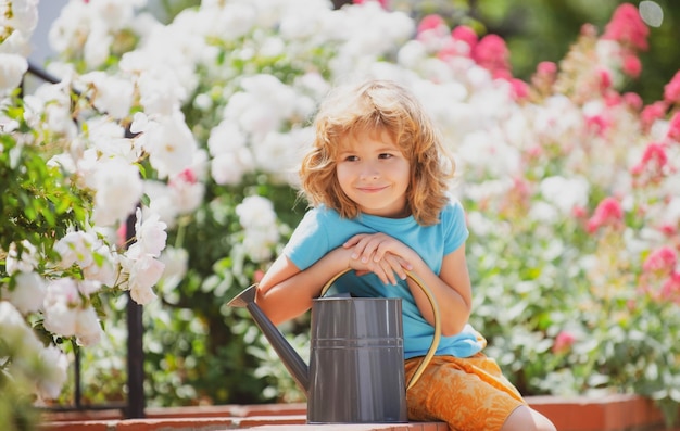 Pequeno agricultor com regador no jardim plantando flores