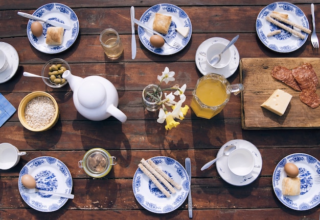 Pequeno-almoço comida de campo fresca na mesa de madeira marrom no jardim, vista superior