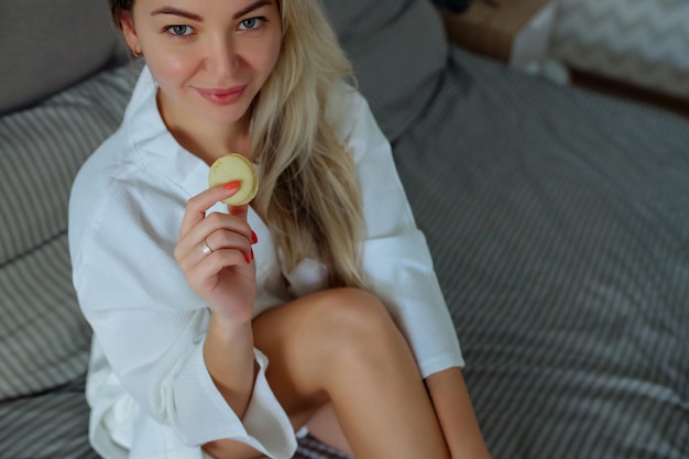 Pequeno-almoço de perto em casa uma rapariga sexy com um roupão de banho branco come macarrão férias no hotel