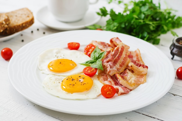 Pequeno-almoço inglês - ovo frito, tomate e bacon.