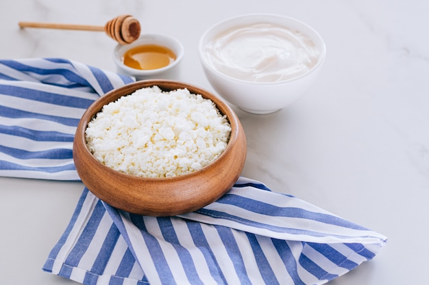 Pequeno-almoço saudável de queijo cottage com creme de leite e mel em uma mesa de mármore