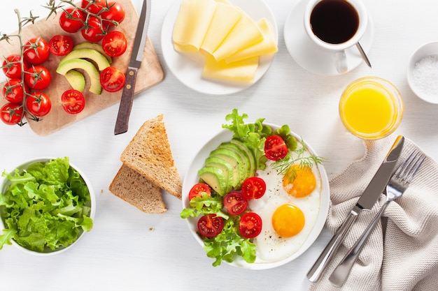 Pequeno-almoço saudável plana leigos. ovos fritos, abacate, tomate, torradas e café