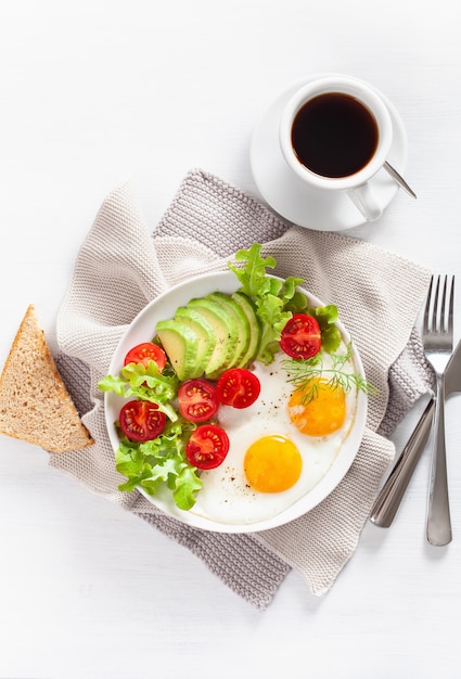 Pequeno-almoço saudável plana leigos. ovos fritos, abacate, tomate, torradas e café