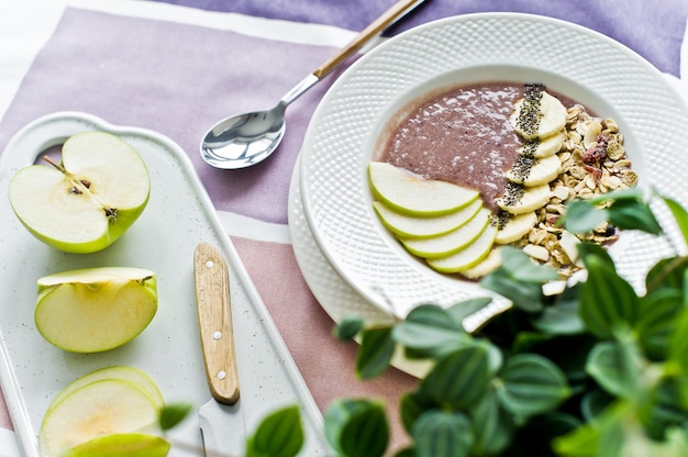 Pequeno-almoço saudável, tigela batido com banana, maçã, sementes de Chia, granola e iogurte.