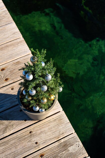 Un pequeño árbol decorado con bolas de Navidad en la vista superior del muelle Foto vertical