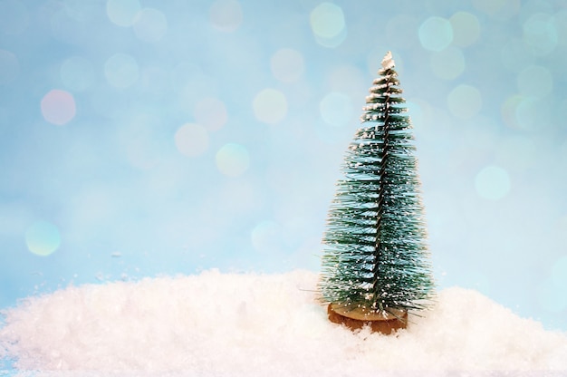 Un pequeño árbol de juguete en la nieve.