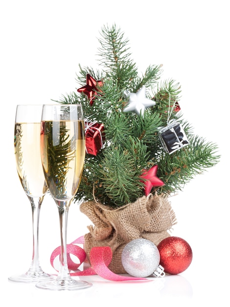 Pequeño árbol de navidad con decoración y dos copas de cava. Aislado sobre fondo blanco