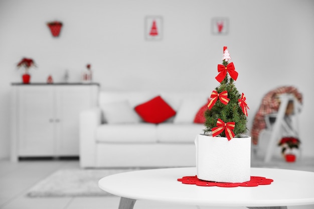 Pequeño árbol de navidad decorado sobre la mesa de la habitación, cerrar