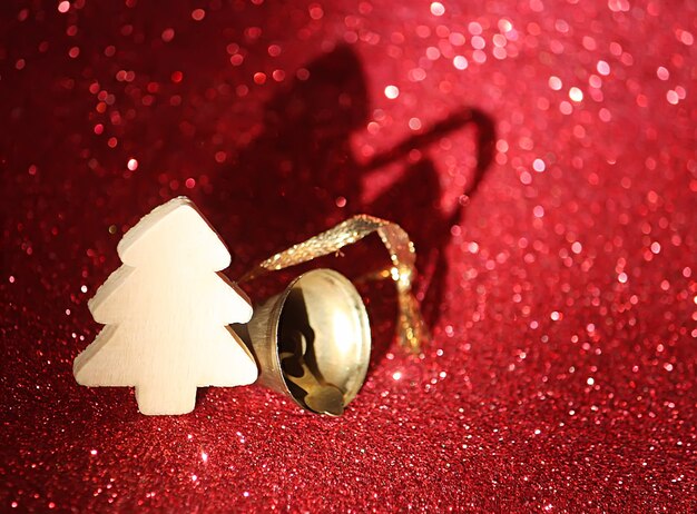 Foto pequeño árbol de navidad de madera decorativa sobre fondo brillante brillo