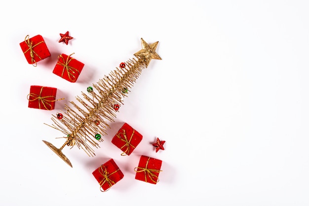 Pequeño árbol de Navidad con punta de estrella y varios regalos en color rojo
