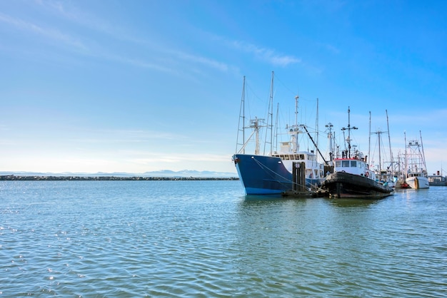 Pequeño arrastrero de pesca y remolcador amarrados en el muelle del océano