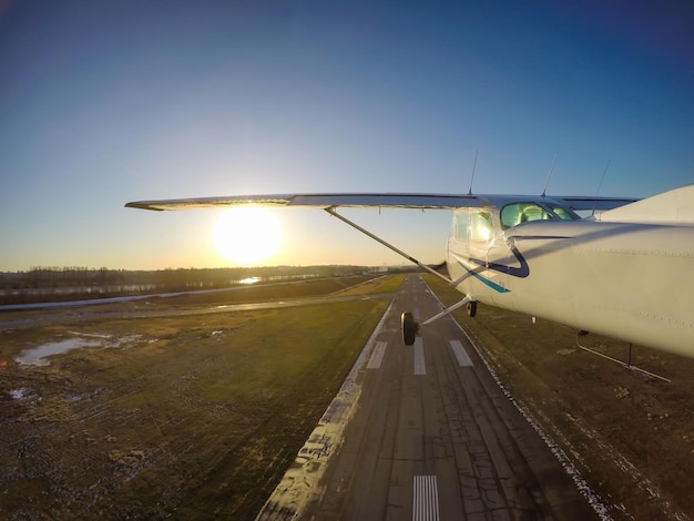 Pequeno avião voando sobre a cidade durante um pôr do sol de inverno vibrante