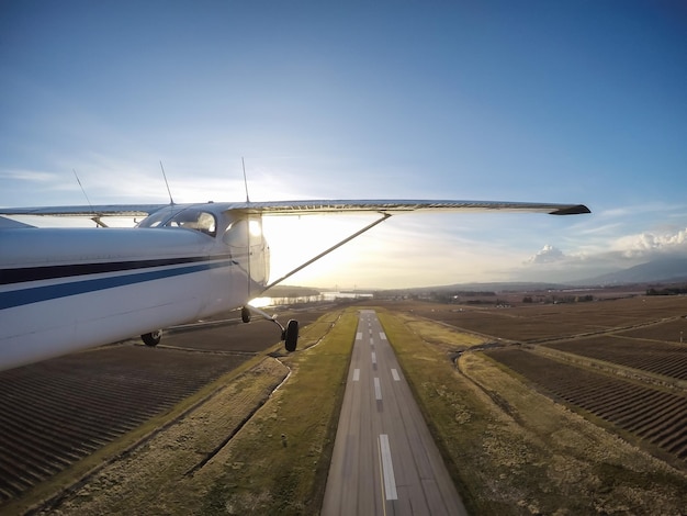 Pequeño avión despegando de la pista durante una vibrante puesta de sol