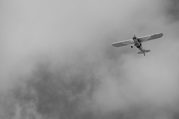 Foto pequeño avión haciendo piruetas en el cielo nublado