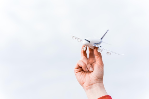 Pequeño avión de juguete volando en el cielo en la mano del hombre Símbolo del fin de la cuarentena y el autoaislamiento debido a la pandemia del coronavirus covid19 Apertura de fronteras entre países y comienzo de vuelos